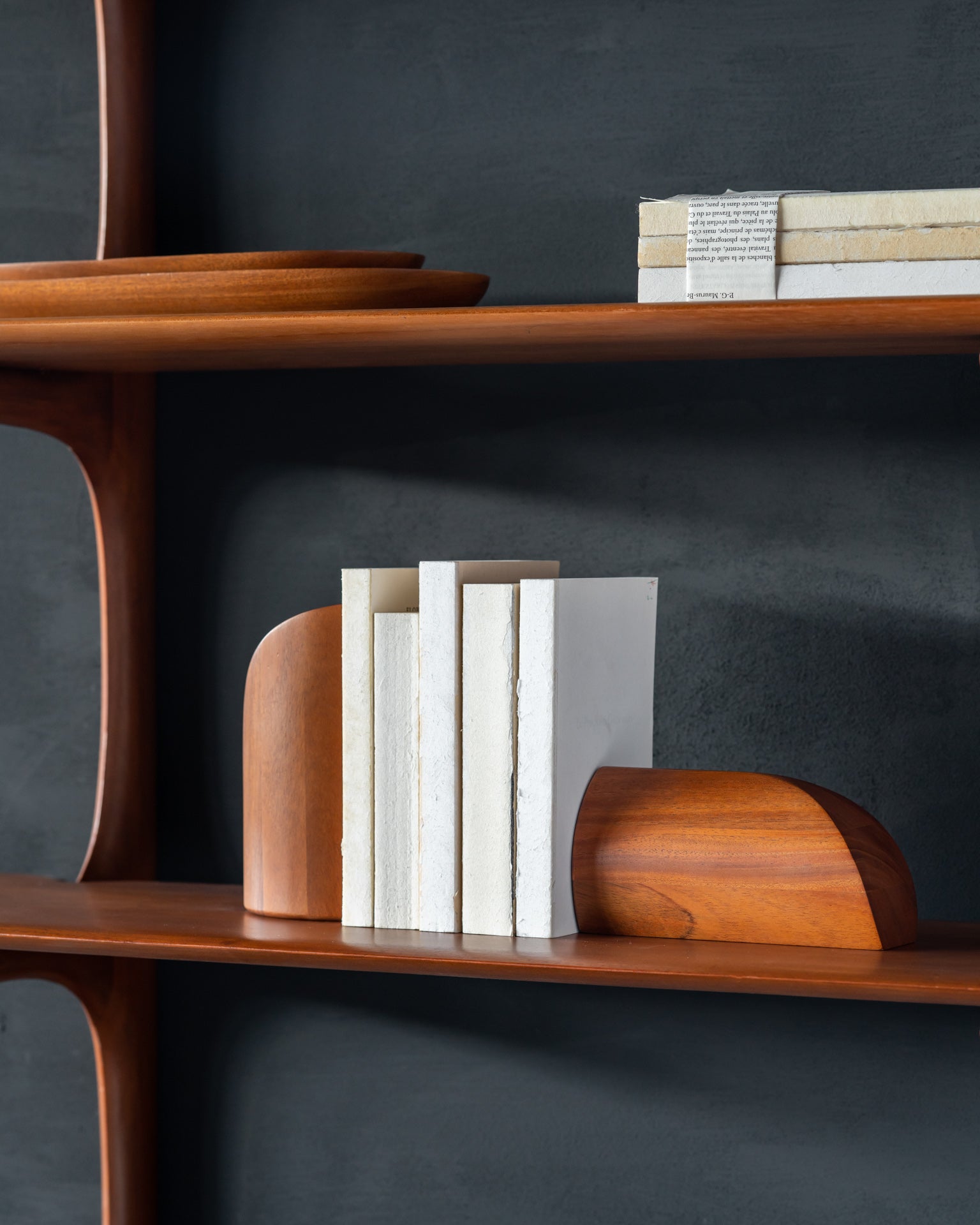 PI-bookends-in-mahogany-PI-wall-shelf-3-shelves-thin-oval-boards-mahogany-Goode-Studio