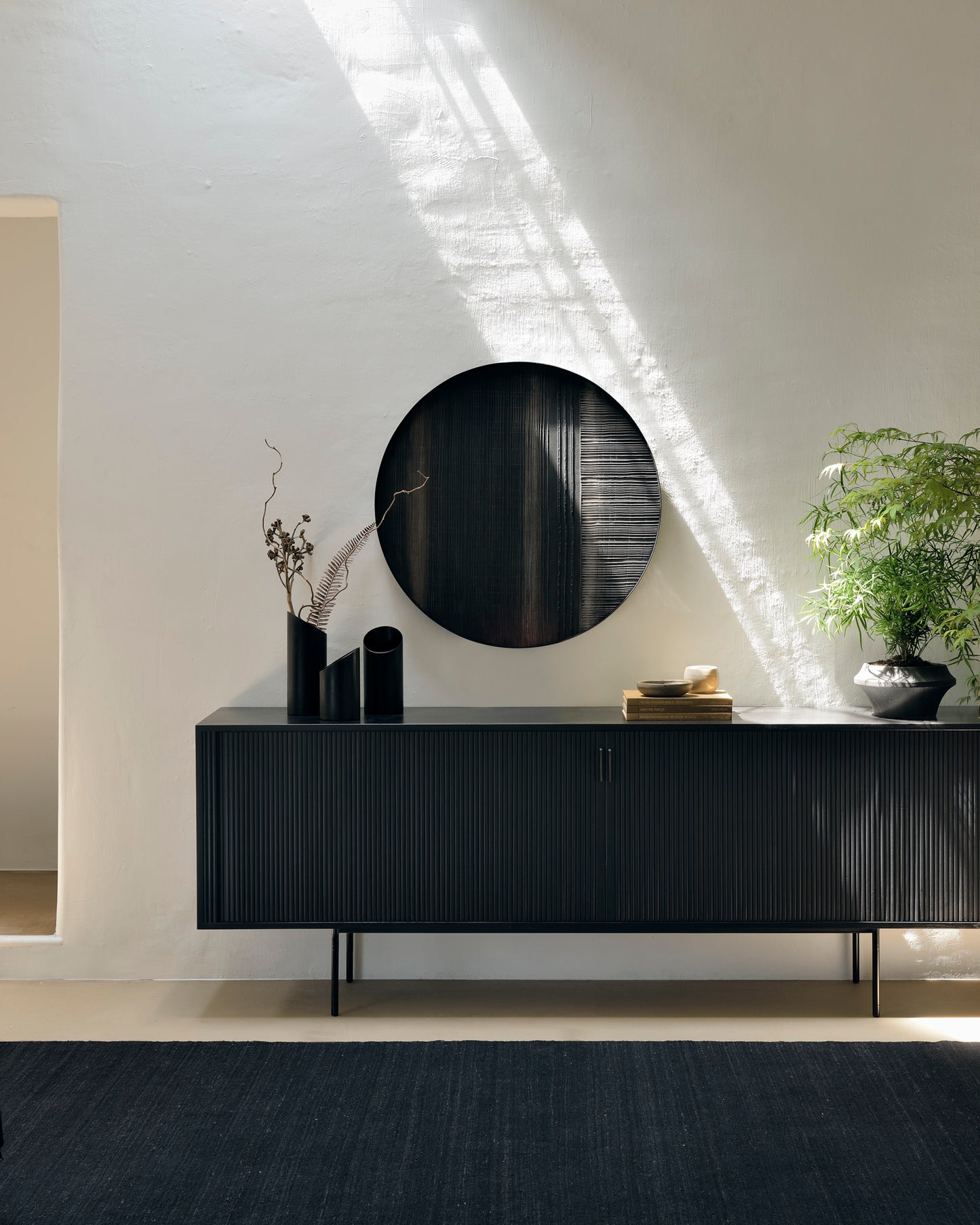 Roller-Max-black-sideboard-with-layered-clay-wall-art-and-dark-chocolate-kilim-rug-Goode-Studio