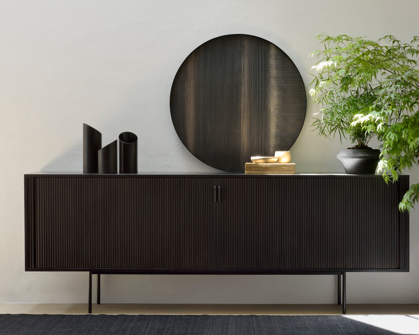 Roller-Max-black-sideboard-with-layered-clay-wall-art-and-dark-chocolate-kilim-rug-Goode-Studio