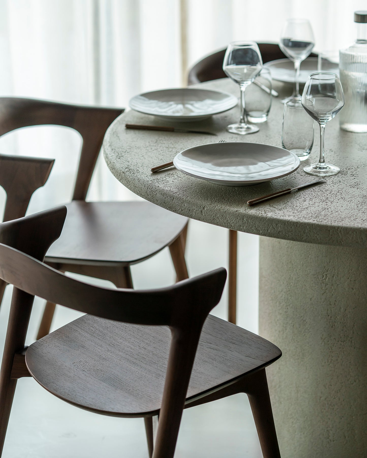 Elements collection round dining table off white stone surface
