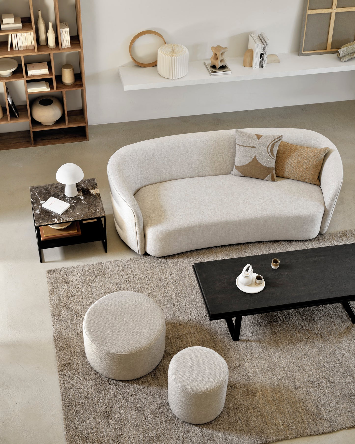 Barrow pouf in off white styled with Ellipse oat table, Emperador stone Stability coffee table, and Cumin Dunes rug by Goode Studio