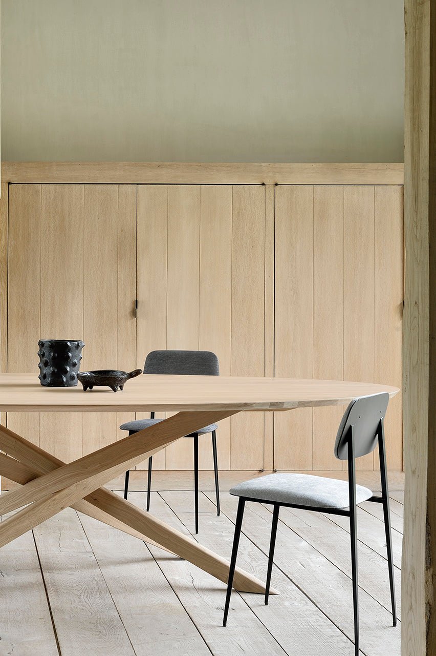 Large oval black oak dining table with sculptural interlocking base
