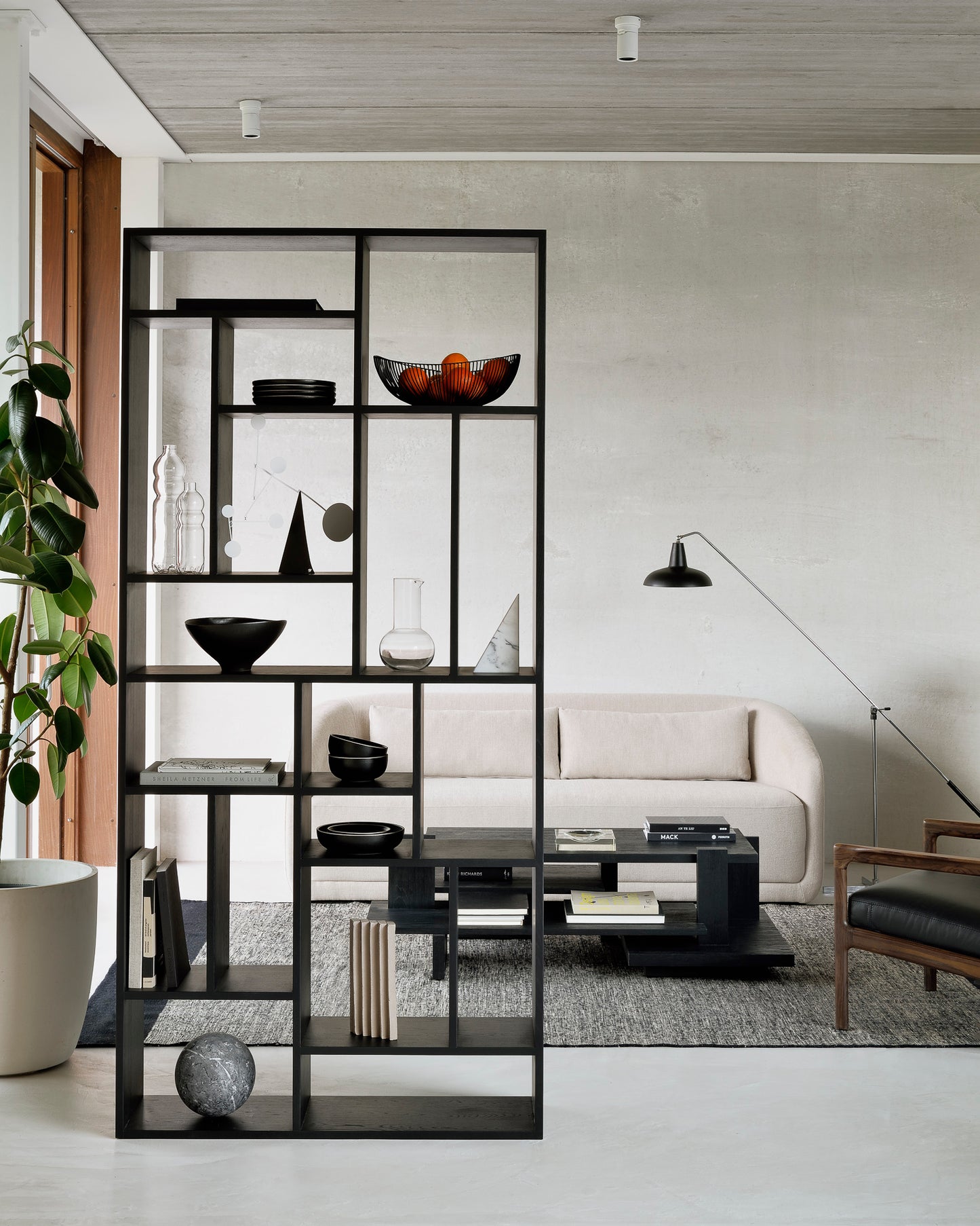 Oak-M-black-rack-Teak-Abstract-black-coffee-table-Trapeze-sofa-3-seater-beige-Lumbar-cushions-beige-Black-Dots-kilim-rug-Goode-Studio