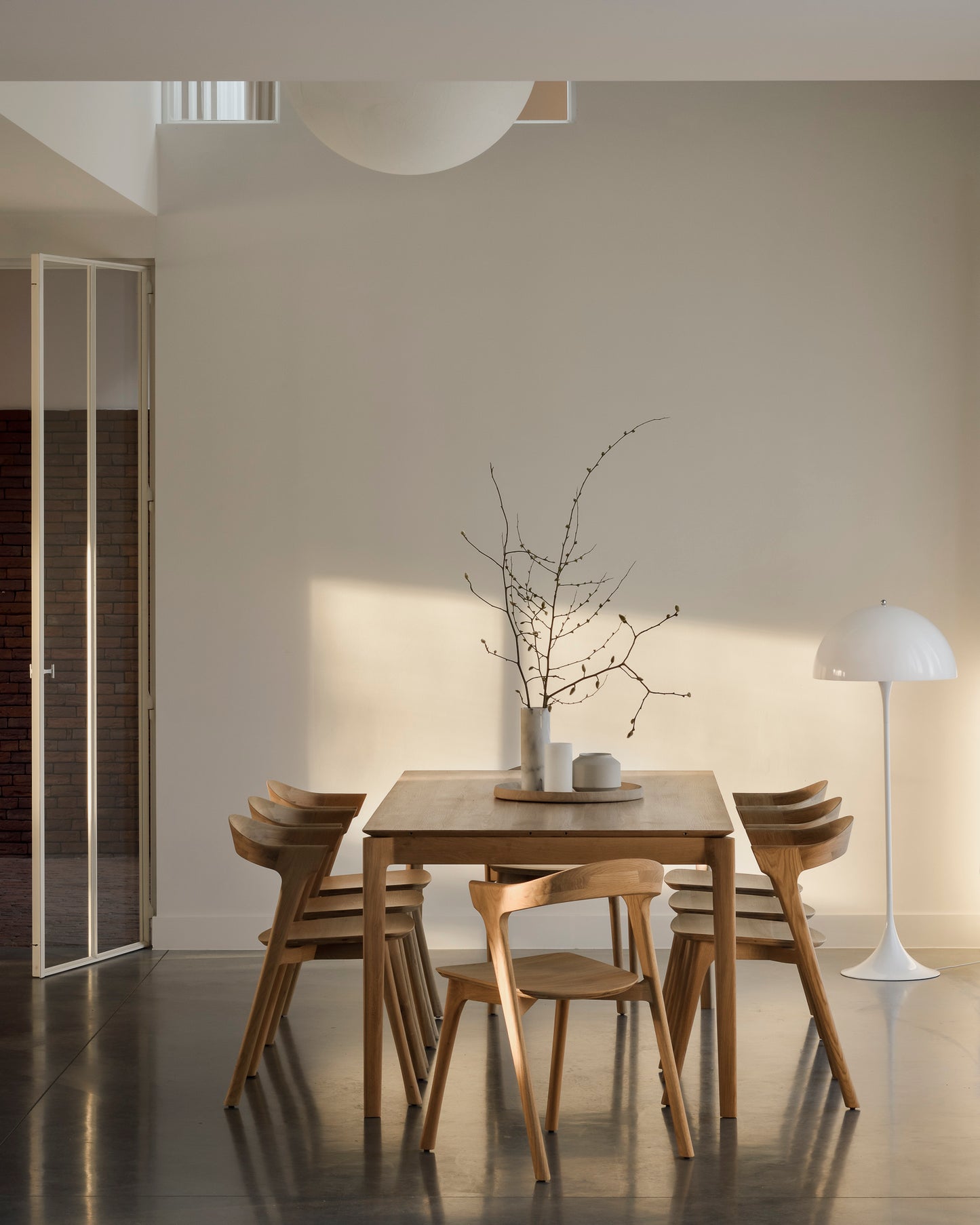 Expandable solid oak dining table with sculptural curved base
