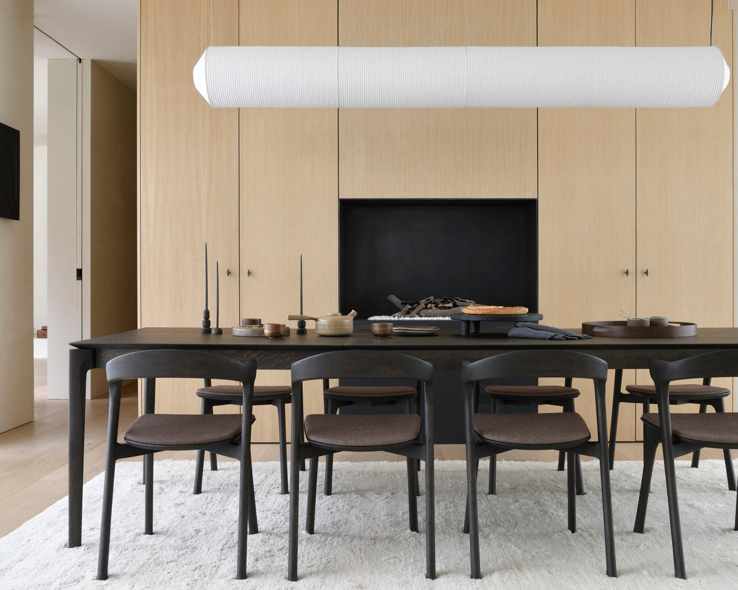 Bok extendable dining table in oak brown with Bok chairs in warm brown fabric and Sand Dunes rug by Goode Studio