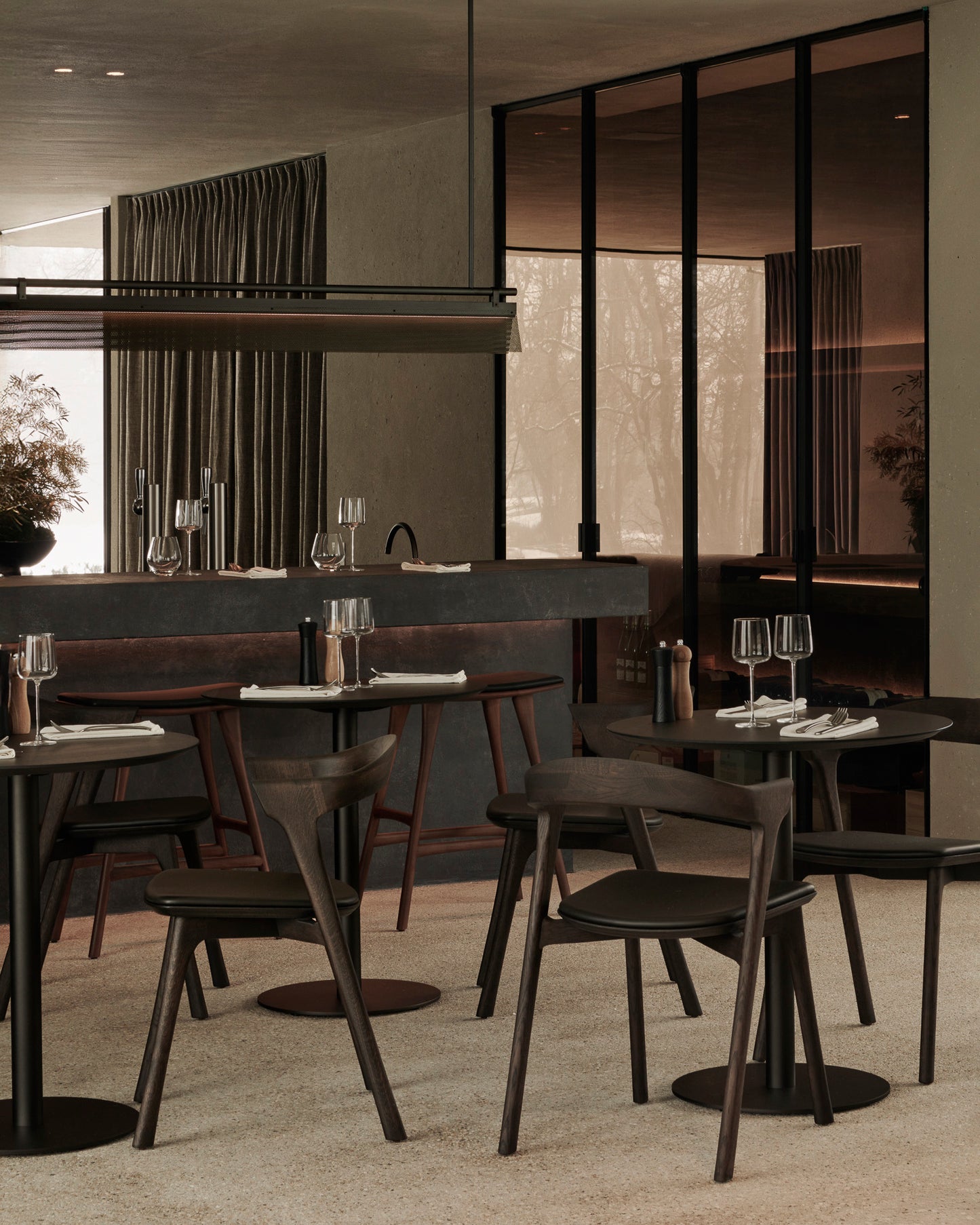 Modern restaurant interior with tables and chairs.